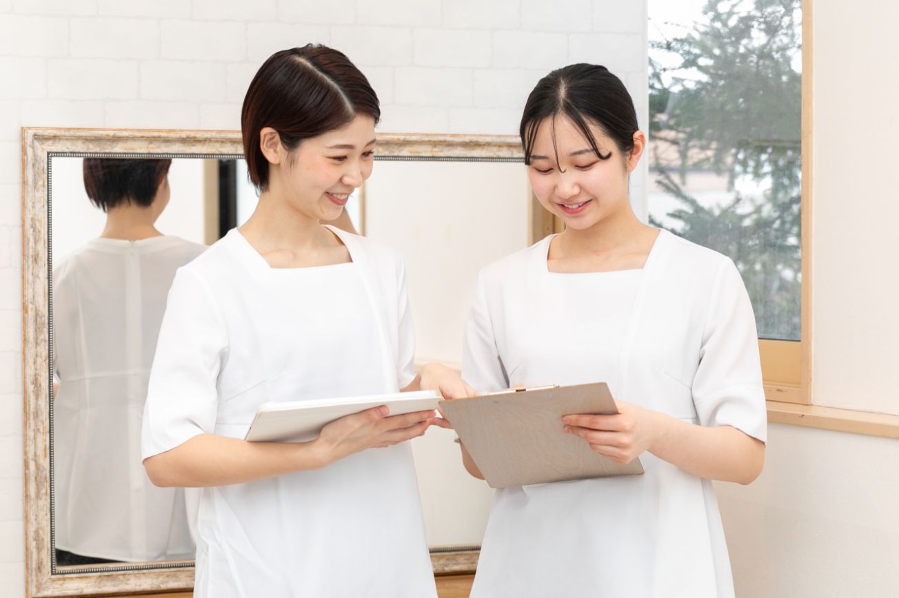 アイパッドを持ってスタッフと会話する山村さんの画像。スタッフはメモに書き込みをしている